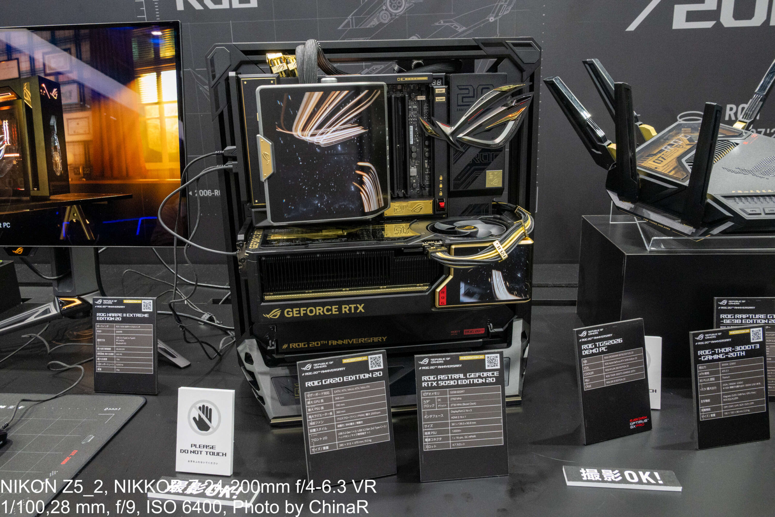 ROG GR20 EDITION 20のオープンフレームで組んだROG TGS2026 DEMO PCの実機と、周囲に並ぶEdition 20各製品の仕様カード