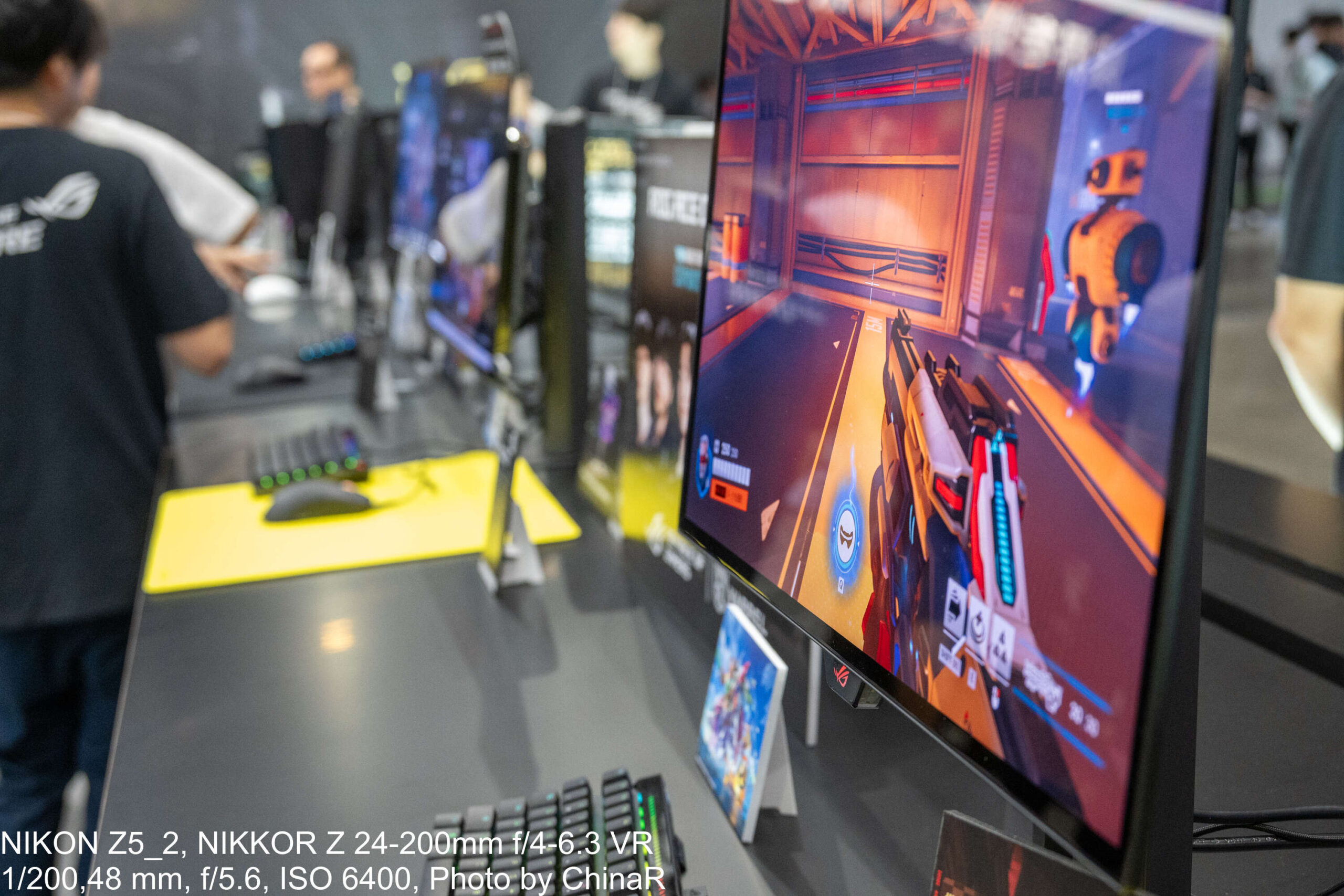 ROG Strix OLED XG259QWPG Aceの試遊席。ROGキーボードと黄色いマウスパッドが並ぶeスポーツ用のブース