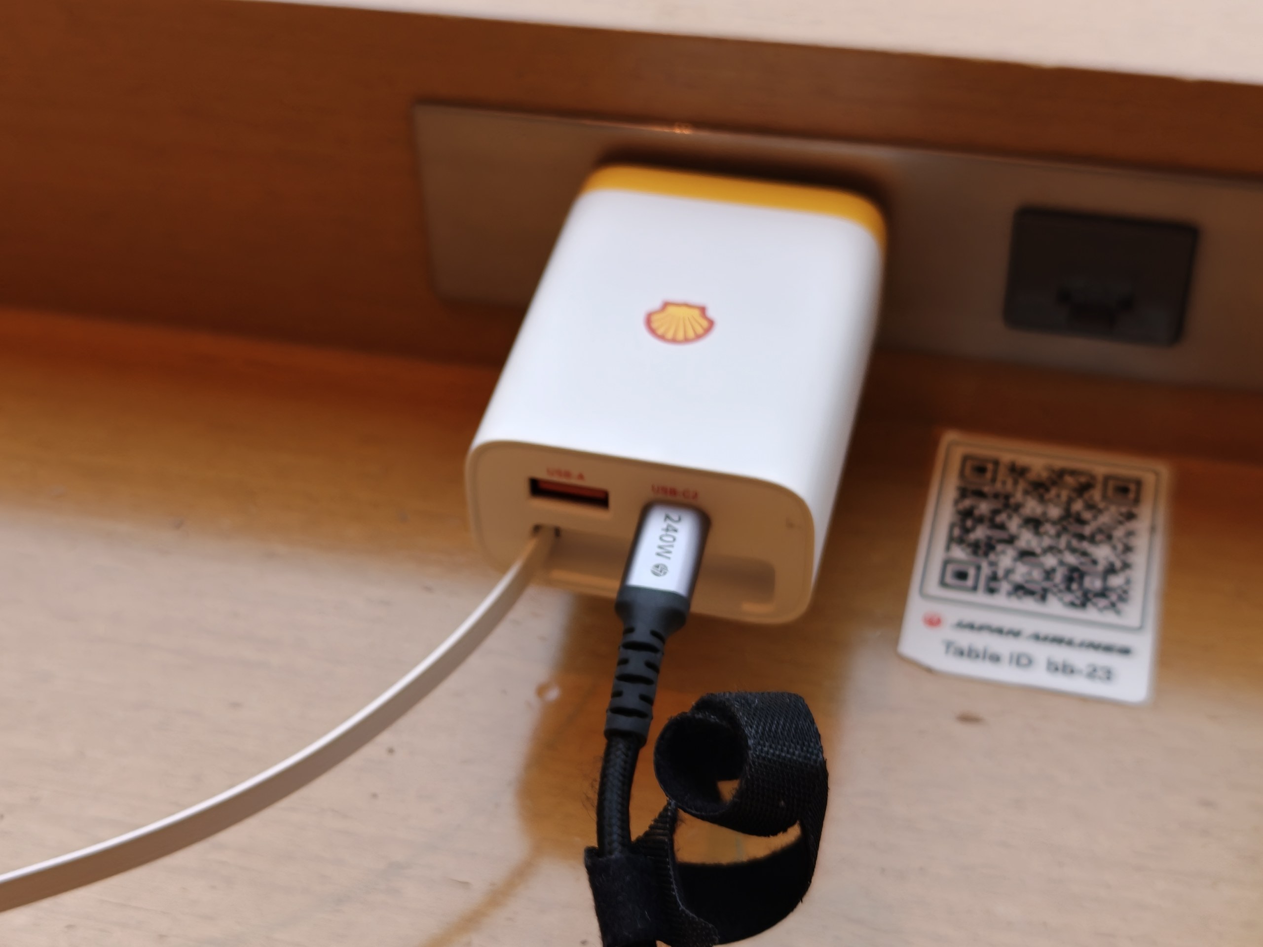成田空港JALサクララウンジのコンセントに挿したケーブル巻き取りタイプの充電器