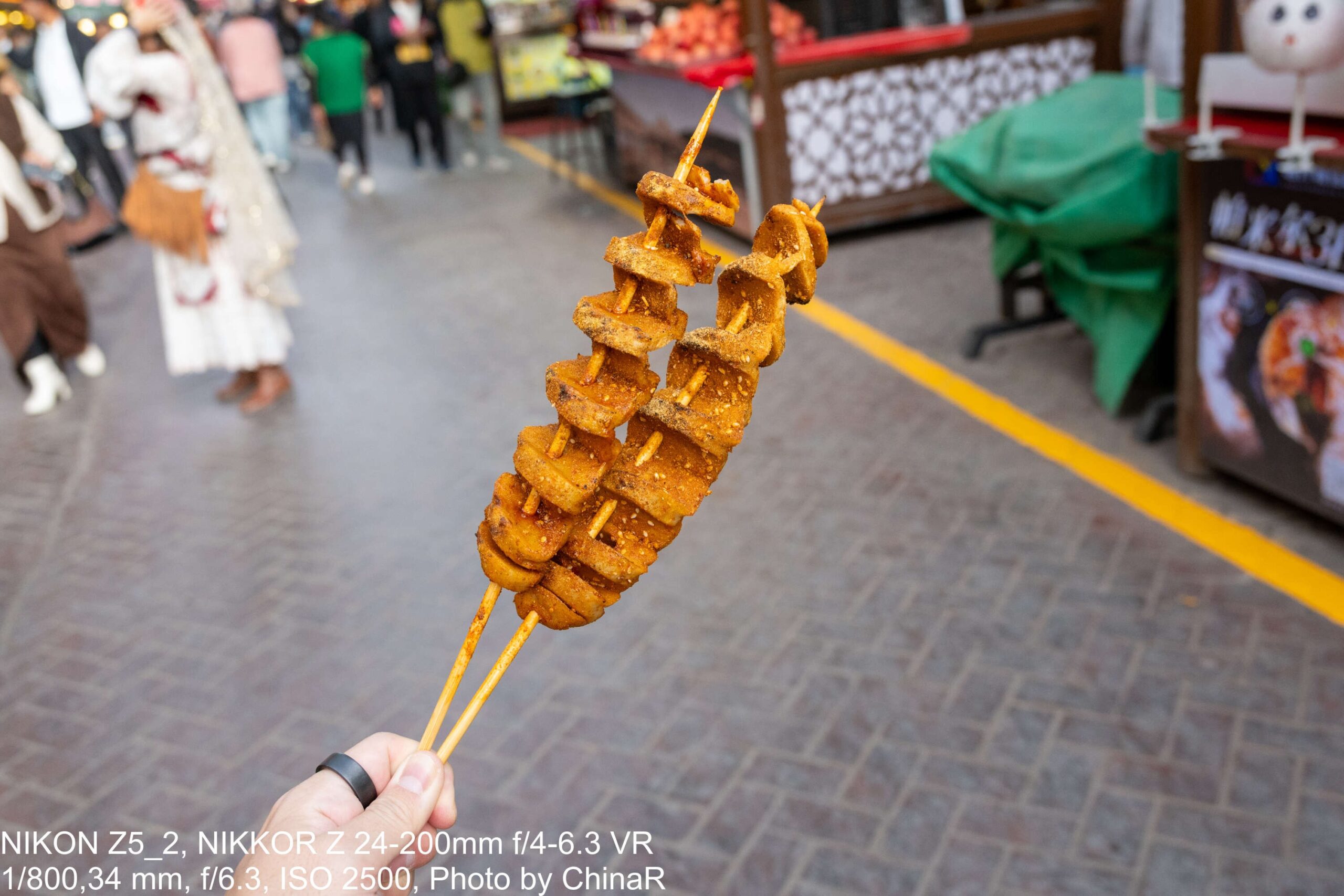 カシュガル古城の路地で手に持った焼き麩の串