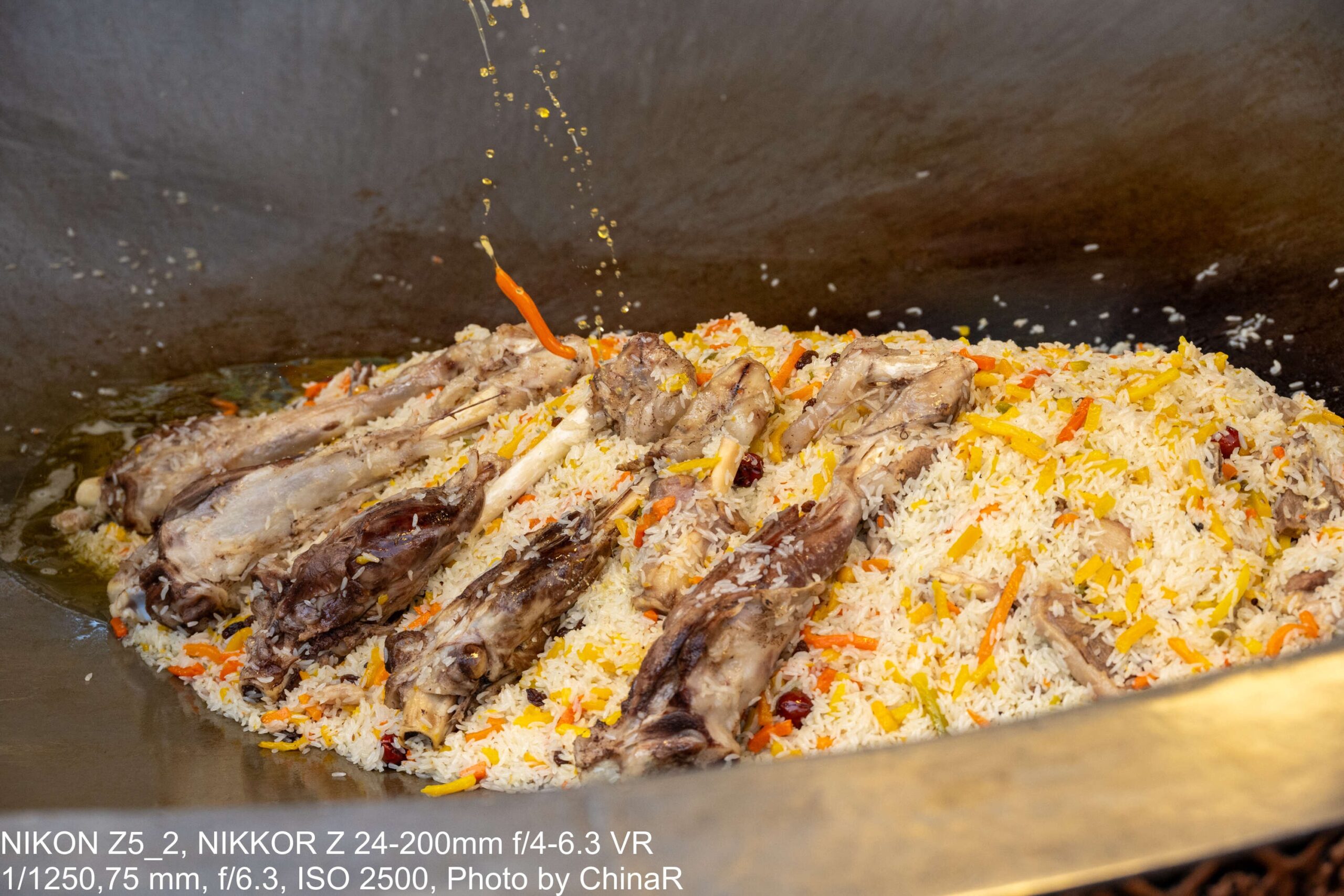 大鍋のプロフ。黄色いニンジンのご飯に並ぶ羊のあばら肉