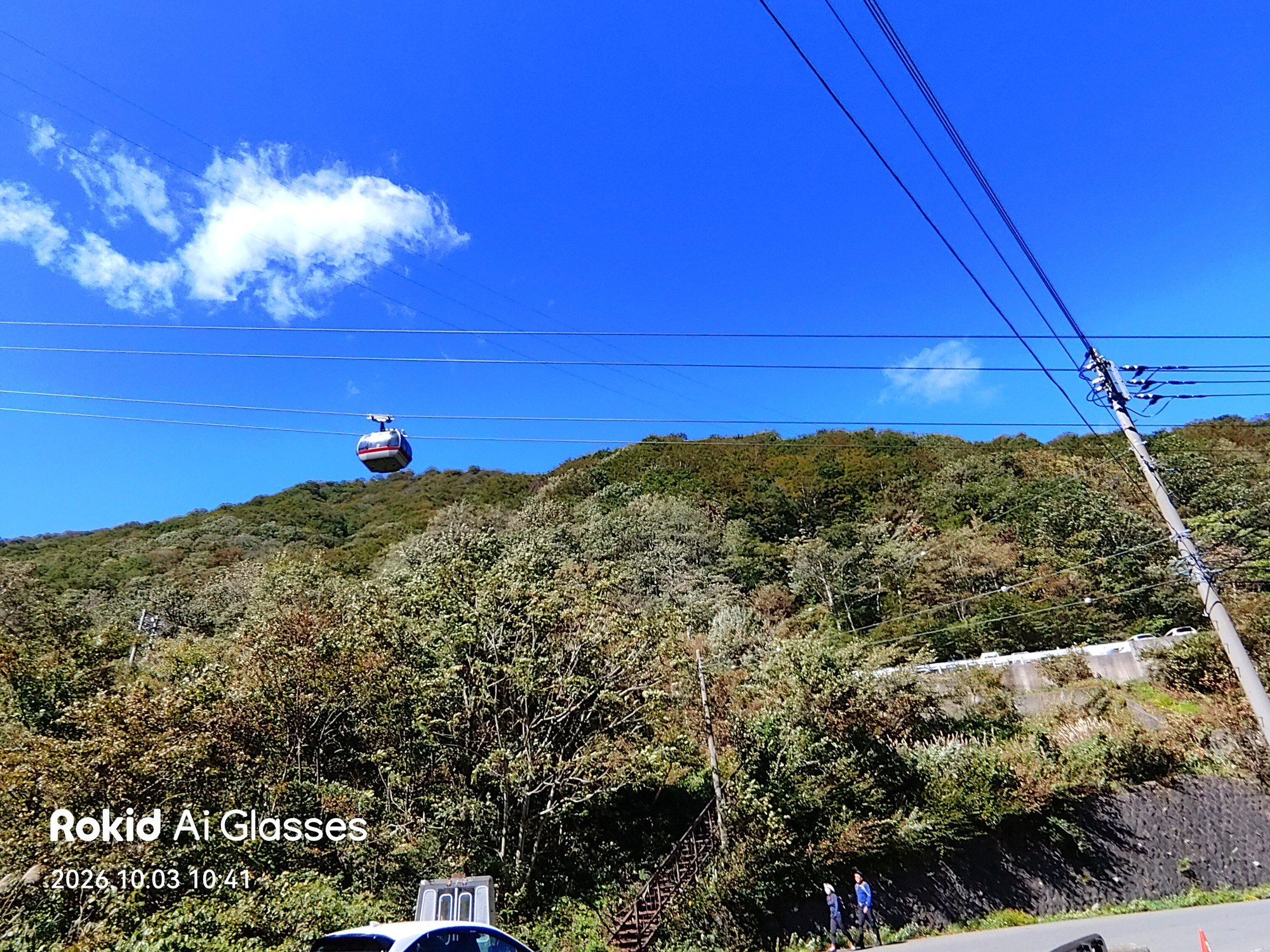 青空を横切る谷川岳ロープウェイのゴンドラ(Rokidで撮影)