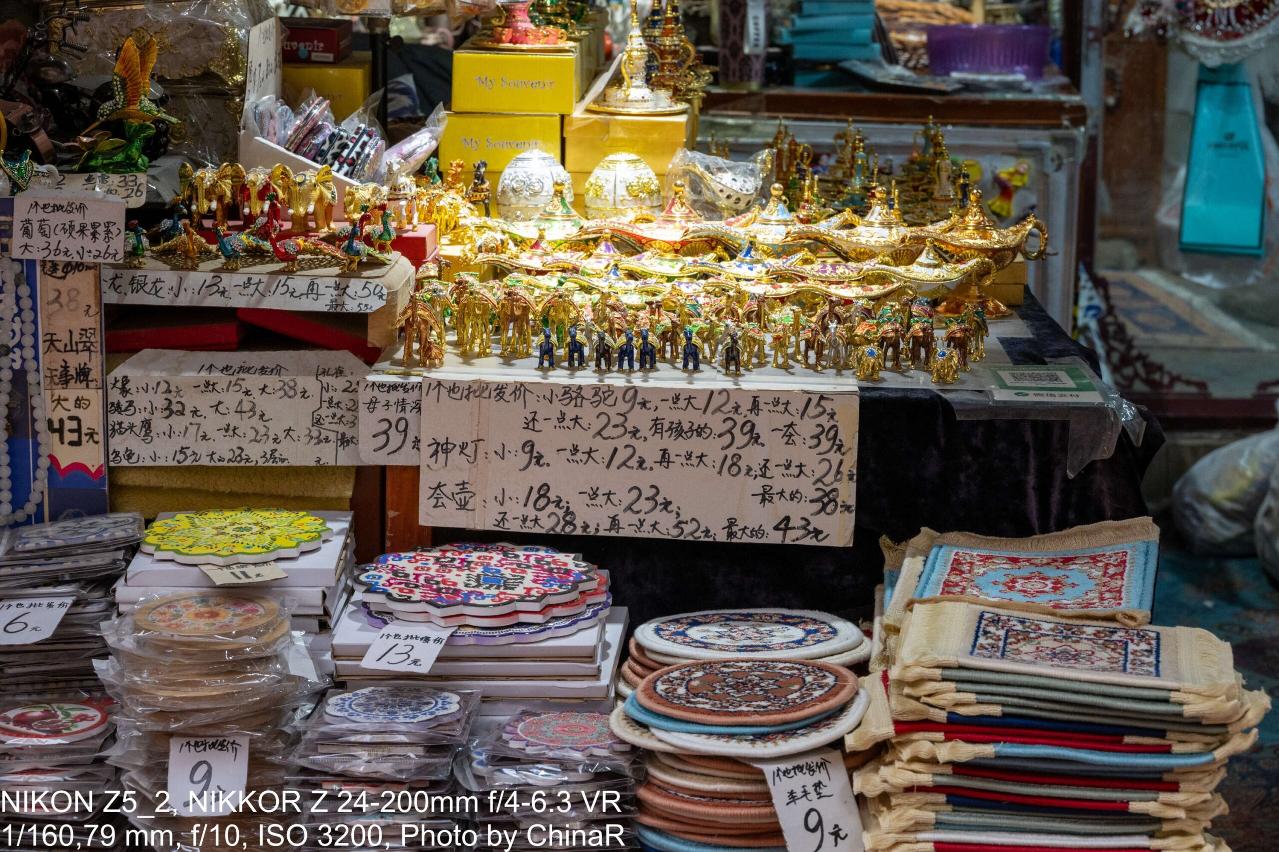 金色のランプ形の置物と刺繍のコースターが並ぶ土産物店