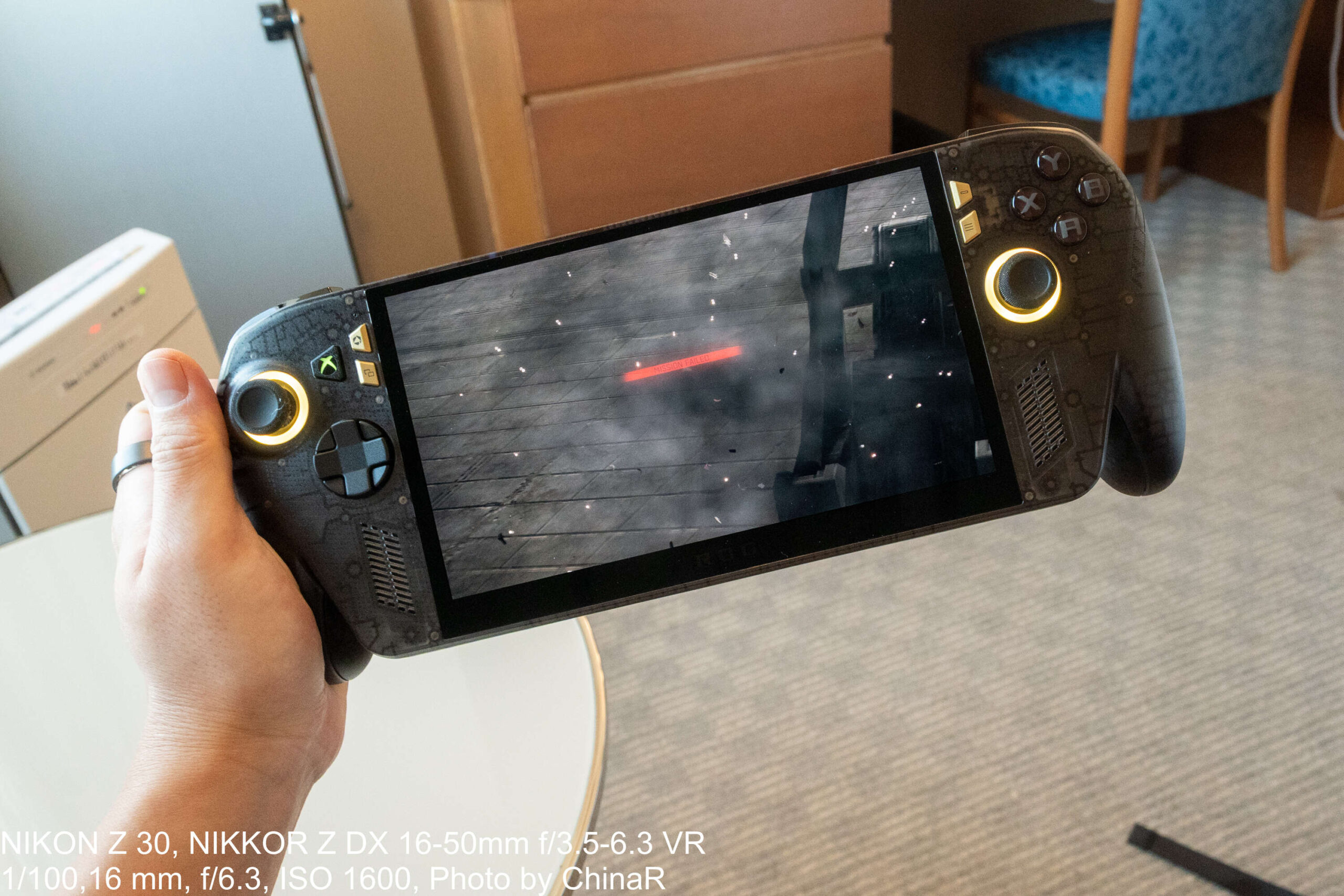 ホテルの客室でROG XBOX Ally X20を手に持ってプレイ