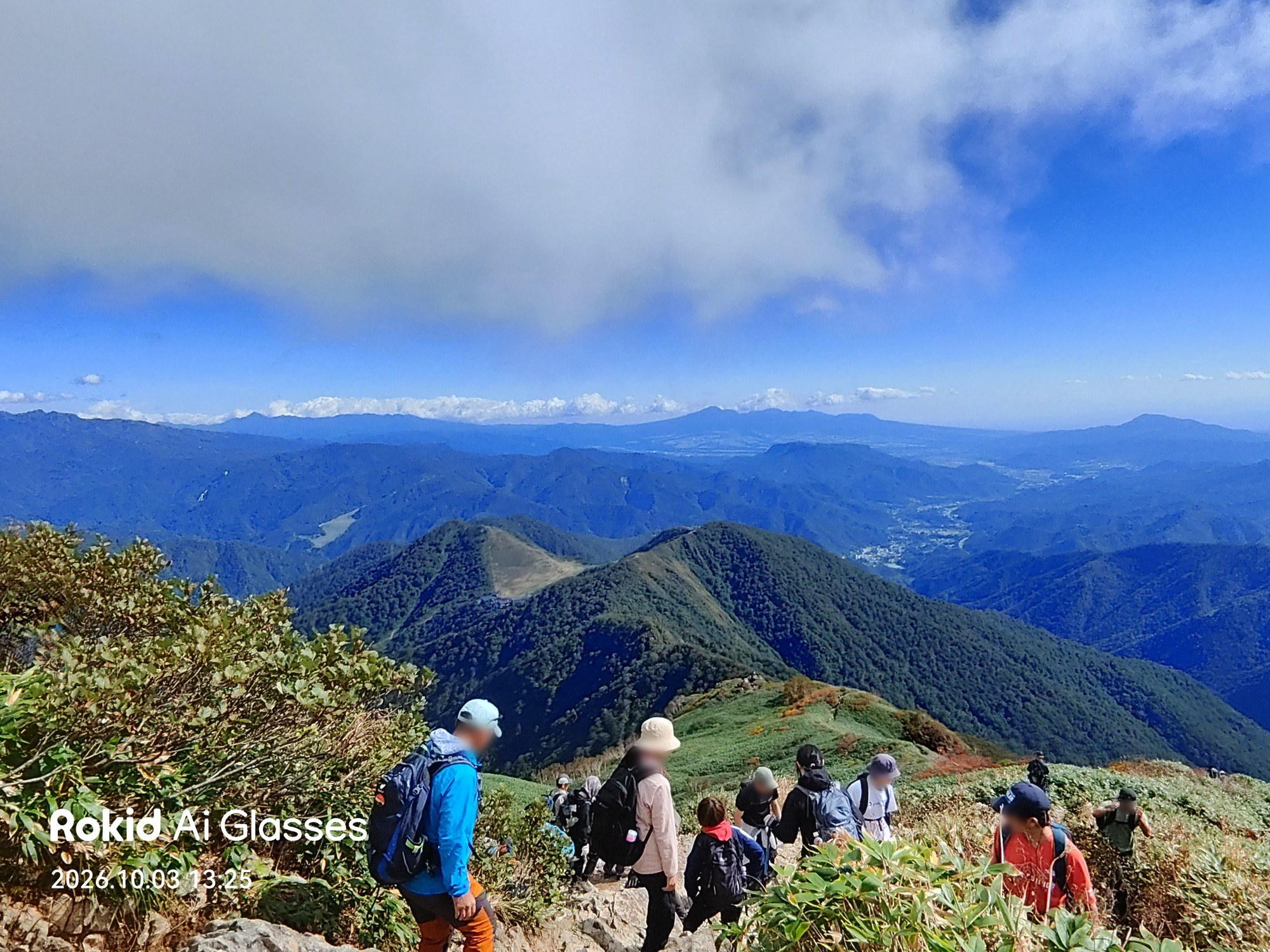 登山者の列と麓まで広がる山並み(Rokidで撮影)